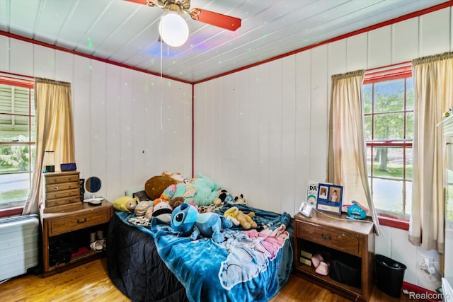 1250 W Thompson Rd, Fenton, MI 48430 - bedroom with wood finished floors, a ceiling fan, and wood walls