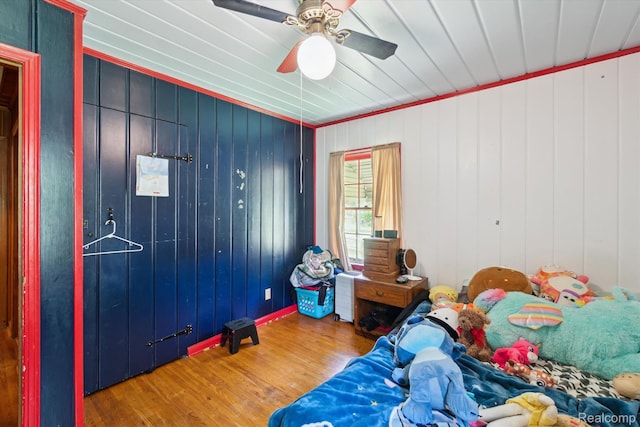 1250 W Thompson Rd, Fenton, MI 48430 - bedroom featuring wood finished floors, ceiling fan, ornamental molding, and wooden walls