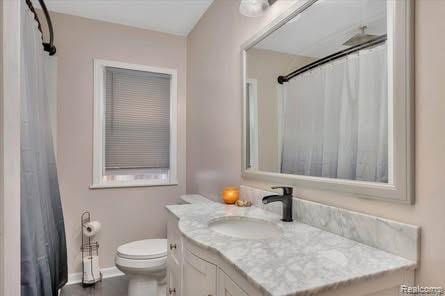 4131 Wellman Line Rd, Brown City, MI 48416 - bathroom featuring vanity, toilet, curtained shower, and baseboards