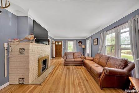 4131 Wellman Line Rd, Brown City, MI 48416 - living room with light wood-type flooring, a fireplace, baseboards, and ornamental molding