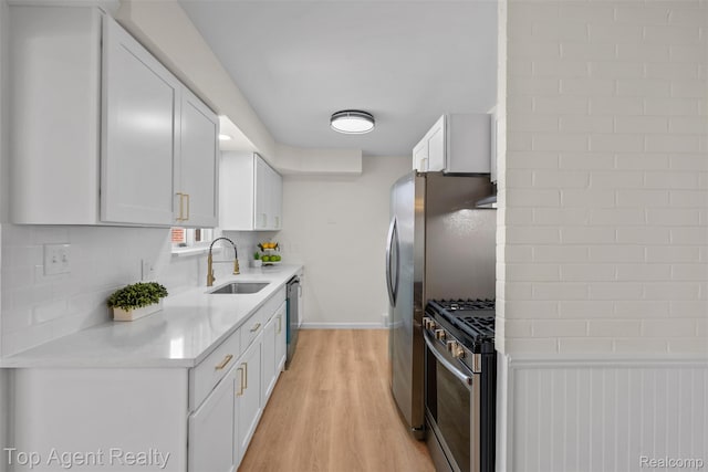 32532 Steinhauer St, Westland, MI 48186 - kitchen with appliances with stainless steel finishes, a sink, light wood-style floors, light countertops, and white cabinets