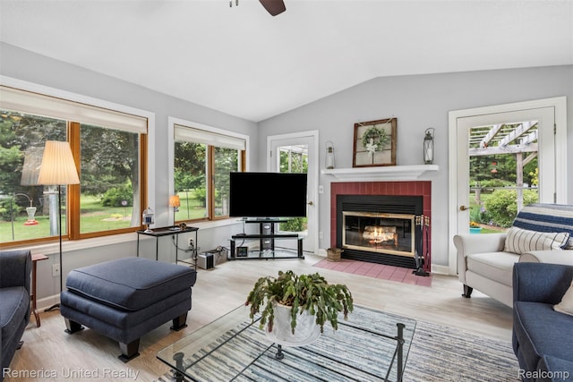 3875 Zimmer Rd, Williamston, MI 48895 - living area featuring vaulted ceiling, wood finished floors, a fireplace, and ceiling fan