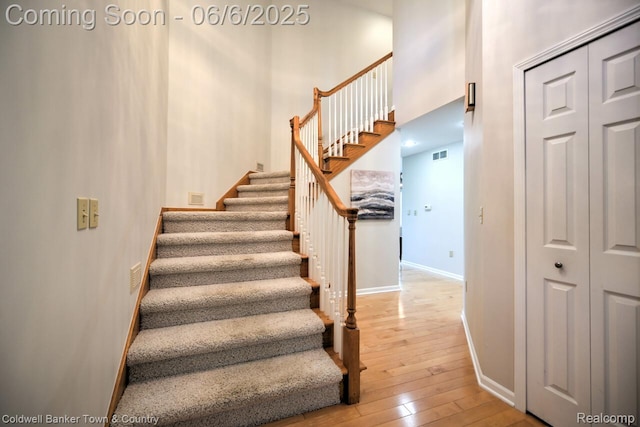 11265 N Shore Dr, Whitmore Lake, MI 48189 - staircase featuring hardwood / wood-style flooring, baseboards, and a high ceiling