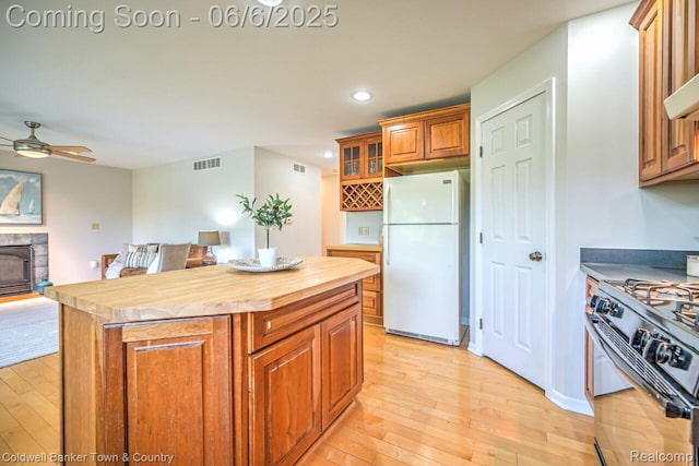 11265 N Shore Dr, Whitmore Lake, MI 48189 - kitchen with freestanding refrigerator, gas stove, butcher block counters, light wood-style flooring, and a ceiling fan