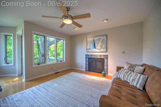 11265 N Shore Dr, Whitmore Lake, MI 48189 - living room featuring a fireplace, baseboards, ceiling fan, and wood finished floors