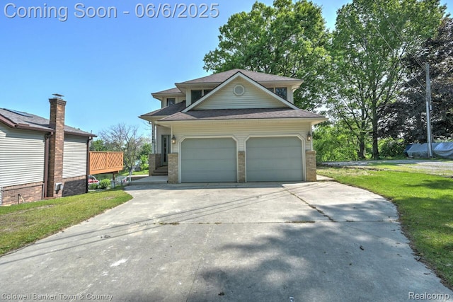 11265 N Shore Dr, Whitmore Lake, MI 48189 - view of front of property with driveway, a garage, brick siding, and a front yard