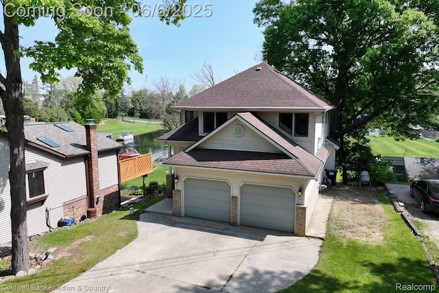 11265 N Shore Dr, Whitmore Lake, MI 48189 - view of front of home with a shingled roof, concrete driveway, a garage, brick siding, and a front yard