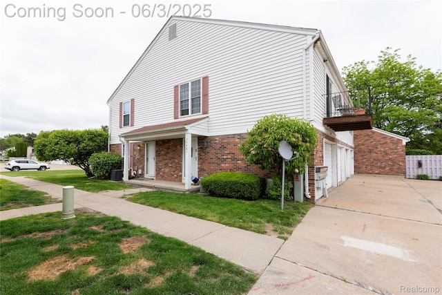 35485 Stillmeadow Ln, Clinton Township, MI 48035 - view of side of home featuring brick siding, concrete driveway, a balcony, central AC unit, and an attached garage