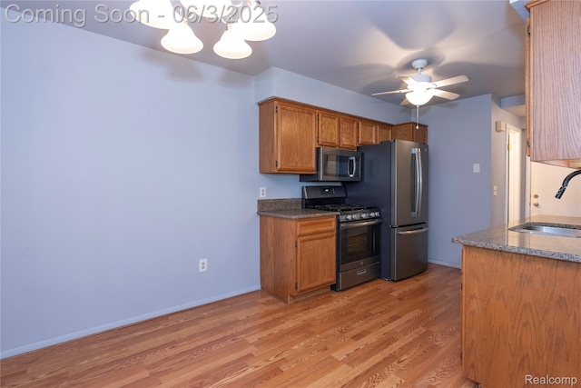 35485 Stillmeadow Ln, Clinton Township, MI 48035 - kitchen with stainless steel appliances, a sink, light wood finished floors, brown cabinetry, and a ceiling fan