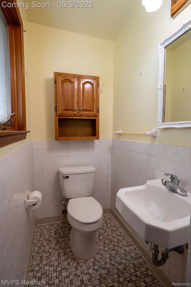 33316 Fraser Ave, Fraser, MI 48026 - bathroom with toilet, tile walls, a sink, wainscoting, and tile patterned floors