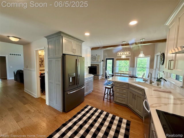 13999 French Ln, Davisburg, MI 48350 - kitchen featuring stainless steel appliances, gray cabinets, a peninsula, light wood-type flooring, and a wainscoted wall