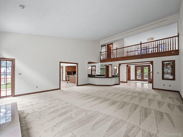 4932 Susans Way, Bloomfield Hills, MI 48302 - unfurnished living room featuring carpet, a towering ceiling, healthy amount of natural light, and baseboards