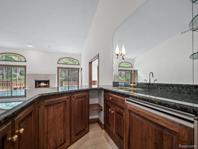 4932 Susans Way, Bloomfield Hills, MI 48302 - kitchen featuring a sink, dishwashing machine, a premium fireplace, dark stone countertops, and light tile patterned flooring