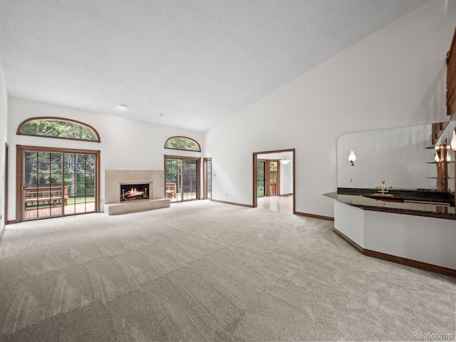 4932 Susans Way, Bloomfield Hills, MI 48302 - unfurnished living room with light colored carpet, high vaulted ceiling, baseboards, and a fireplace