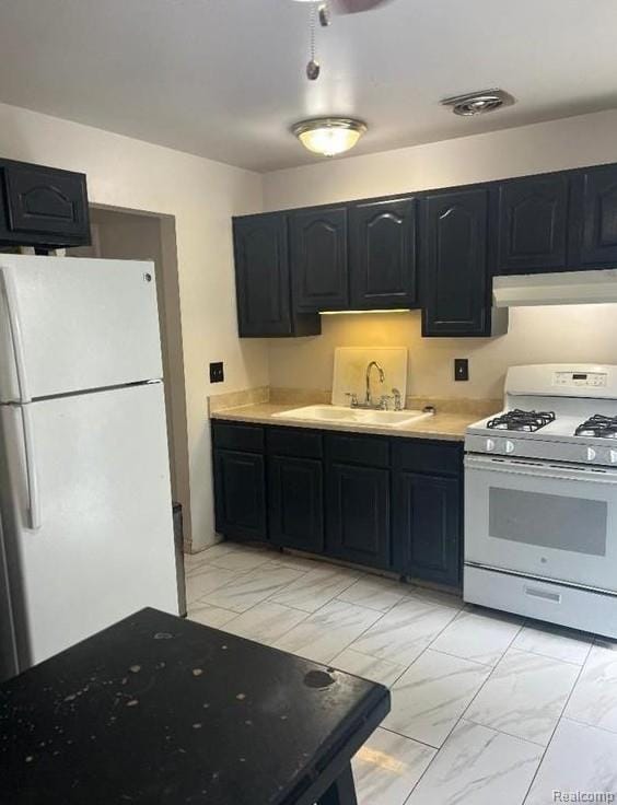 41541 Mcbride Ave, Van Buren, MI 48111 - kitchen with white appliances, light marble finish floors, a sink, and wall chimney range hood