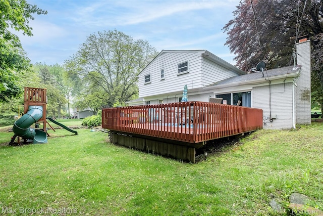 2655 Aspen Ln, Bloomfield Hills, MI 48302 - rear view of house featuring a playground, a wooden deck, a yard, a chimney, and brick siding