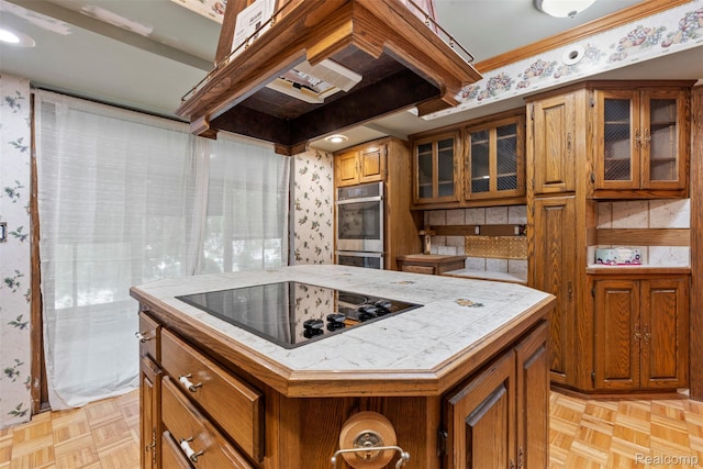 49748 Regatta St, Chesterfield, MI 48047 - kitchen with wallpapered walls, black electric cooktop, tile countertops, brown cabinets, and double oven