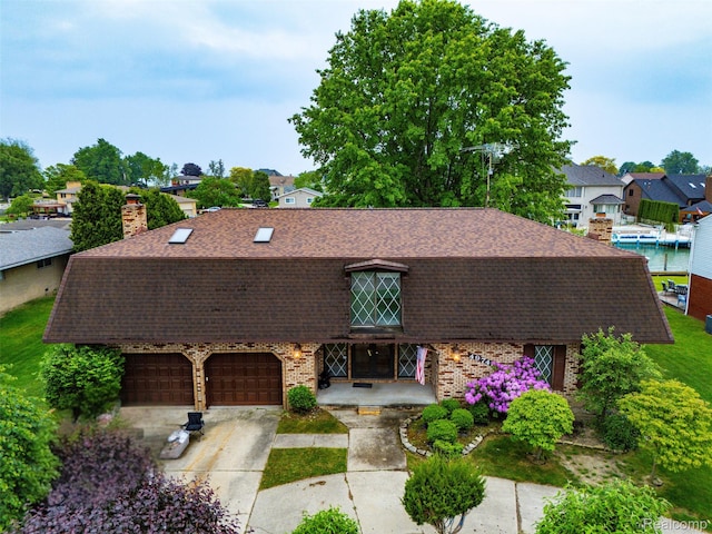 49748 Regatta St, Chesterfield, MI 48047 - colonial inspired home featuring roof with shingles, an attached garage, brick siding, concrete driveway, and a chimney