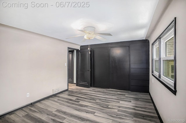 11393 Outer Dr, Pinckney, MI 48169 - unfurnished bedroom with wood finished floors, baseboards, a closet, and a ceiling fan