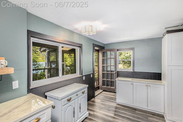 11393 Outer Dr, Pinckney, MI 48169 - kitchen with light countertops, wood finished floors, white cabinetry, and wainscoting