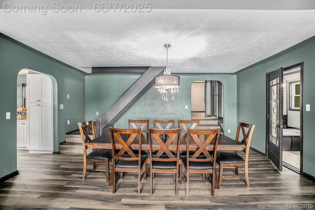 11393 Outer Dr, Pinckney, MI 48169 - dining space featuring arched walkways, wood finished floors, a textured ceiling, and a chandelier
