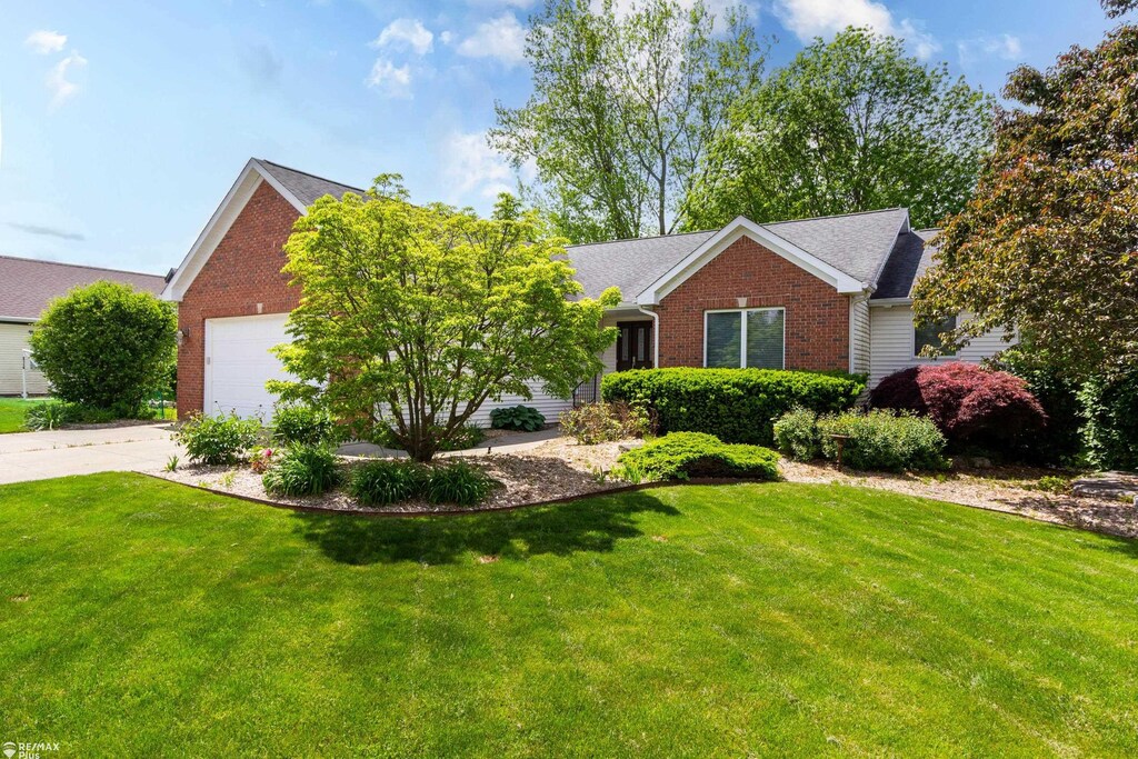 353 Golfside Dr, Lapeer, MI 48446 - view of front of property featuring brick siding, concrete driveway, a garage, and a front lawn