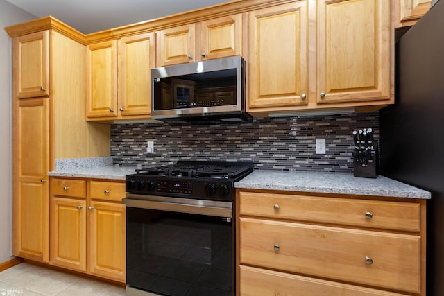 353 Golfside Dr, Lapeer, MI 48446 - kitchen featuring stainless steel microwave, gas range oven, decorative backsplash, and light tile patterned floors
