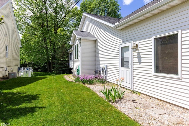 353 Golfside Dr, Lapeer, MI 48446 - view of property exterior featuring a yard, a shingled roof, and central AC unit