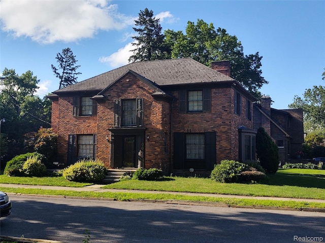 20066 Briarcliff Rd, Detroit, MI 48221 - view of front facade with brick siding, a chimney, and a front lawn