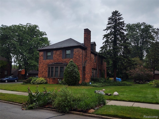 20066 Briarcliff Rd, Detroit, MI 48221 - view of front of house with brick siding, a front yard, and a chimney