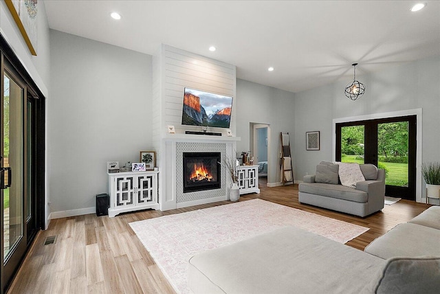 8011 Date Rd, Stevensville, MI 49127 - living area featuring a fireplace, a towering ceiling, wood finished floors, recessed lighting, and baseboards