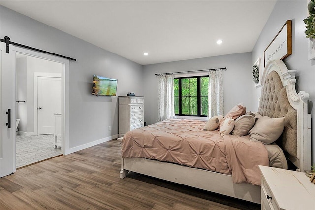 8011 Date Rd, Stevensville, MI 49127 - bedroom featuring a barn door, wood finished floors, recessed lighting, and baseboards