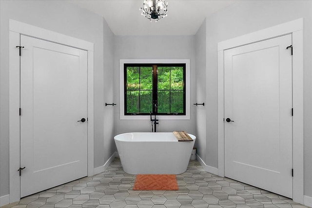 8011 Date Rd, Stevensville, MI 49127 - full bath featuring a freestanding bath, baseboards, tile patterned flooring, and a chandelier