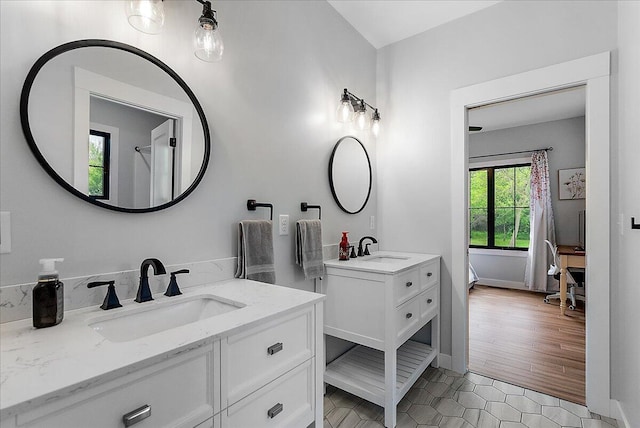 8011 Date Rd, Stevensville, MI 49127 - bathroom with two vanities, baseboards, tile patterned floors, and ensuite bath
