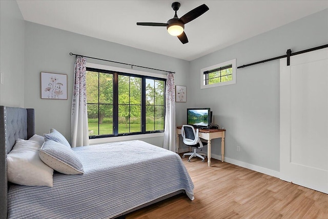 8011 Date Rd, Stevensville, MI 49127 - bedroom with wood finished floors, a barn door, baseboards, a desk, and ceiling fan