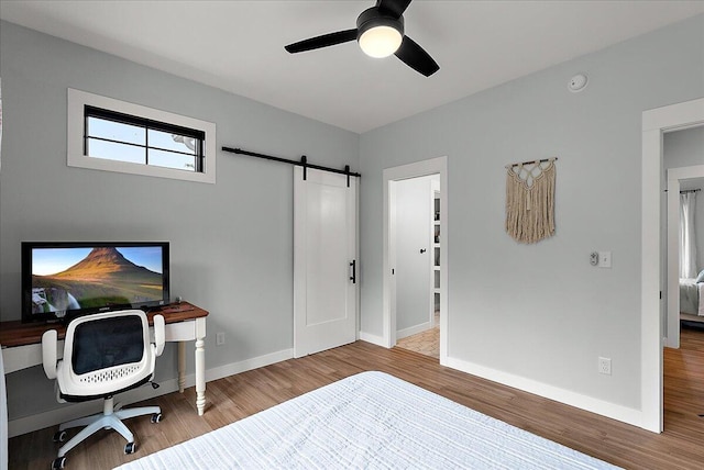 8011 Date Rd, Stevensville, MI 49127 - bedroom with a barn door, wood finished floors, baseboards, and ceiling fan