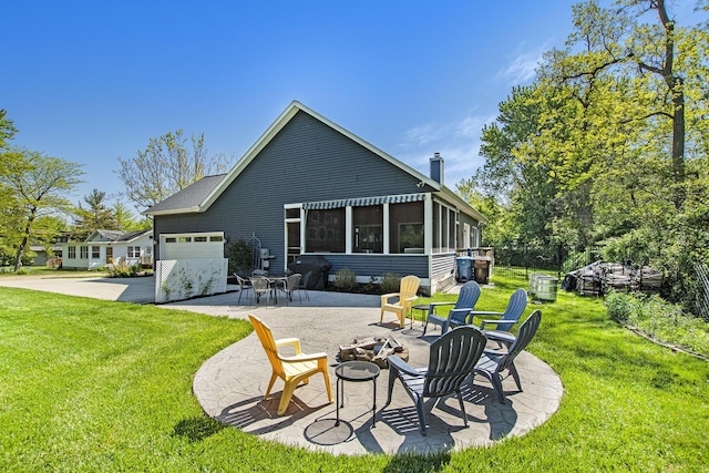 507 A Ave, South Haven, MI 49090 - back of house featuring an outdoor fire pit, a garage, a lawn, concrete driveway, and a sunroom
