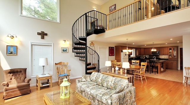 908 W Oak St, Bitely, MI 49309 - living room featuring stairs, light wood-style flooring, a high ceiling, a chandelier, and recessed lighting