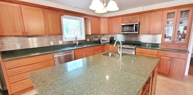 908 W Oak St, Bitely, MI 49309 - kitchen with stainless steel appliances, a sink, a chandelier, and a center island with sink