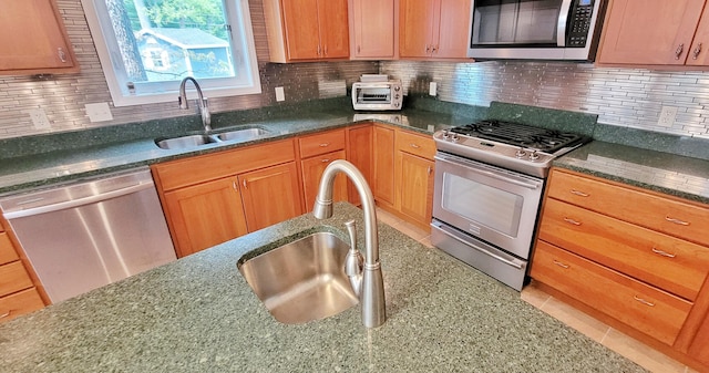 908 W Oak St, Bitely, MI 49309 - kitchen featuring stainless steel appliances, a sink, dark stone countertops, and decorative backsplash