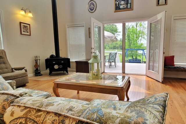908 W Oak St, Bitely, MI 49309 - living room featuring a wood stove, wood finished floors, a high ceiling, and baseboards