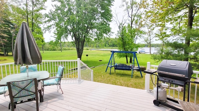 908 W Oak St, Bitely, MI 49309 - deck featuring a lawn, grilling area, outdoor dining area, and a water view