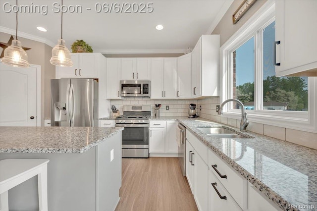 343 Hidden Riv E, Holly, MI 48442 - kitchen with stainless steel appliances, a sink, crown molding, white cabinets, and backsplash
