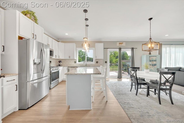 343 Hidden Riv E, Holly, MI 48442 - kitchen featuring appliances with stainless steel finishes, a sink, decorative backsplash, white cabinets, and light wood finished floors