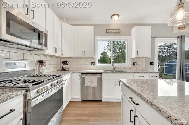 343 Hidden Riv E, Holly, MI 48442 - kitchen featuring appliances with stainless steel finishes, a sink, white cabinetry, light stone counters, and ornamental molding