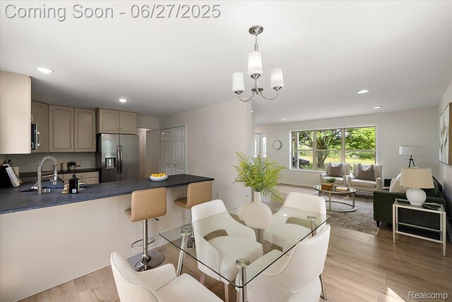 9248 Riverside Dr, Brighton, MI 48116 - kitchen featuring stainless steel appliances, dark countertops, a peninsula, light wood-style floors, and open floor plan