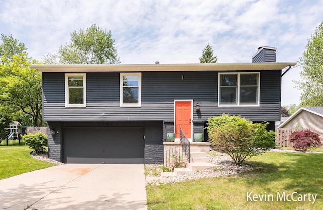 1731 Edgewood Ave SE, Grand Rapids, MI 49506 - bi-level home featuring a chimney, a garage, and concrete driveway