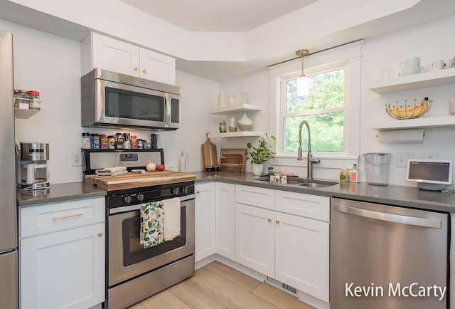 1731 Edgewood Ave SE, Grand Rapids, MI 49506 - kitchen featuring stainless steel appliances, open shelves, a sink, dark countertops, and white cabinets