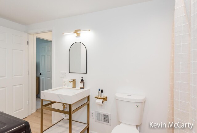 1731 Edgewood Ave SE, Grand Rapids, MI 49506 - bathroom with toilet, wood finished floors, baseboards, a shower, and vanity