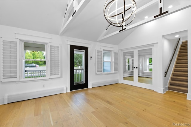 5164 Plymouth Rd, Ann Arbor, MI 48105 - foyer entrance featuring a baseboard radiator, light wood-type flooring, french doors, high vaulted ceiling, and plenty of natural light